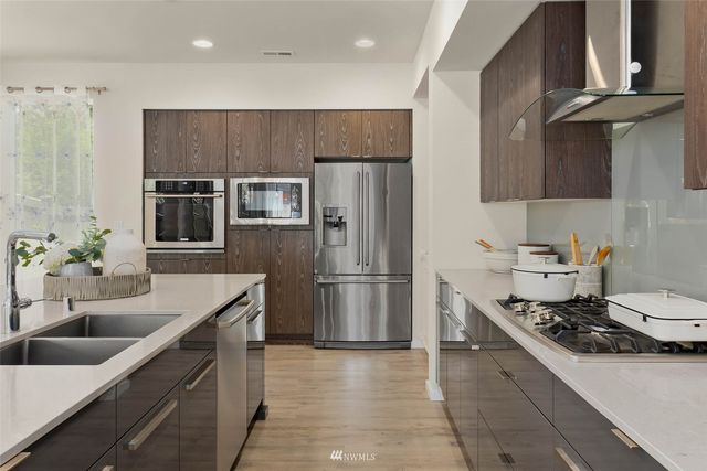 a kitchen with a sink stainless steel appliances and cabinets
