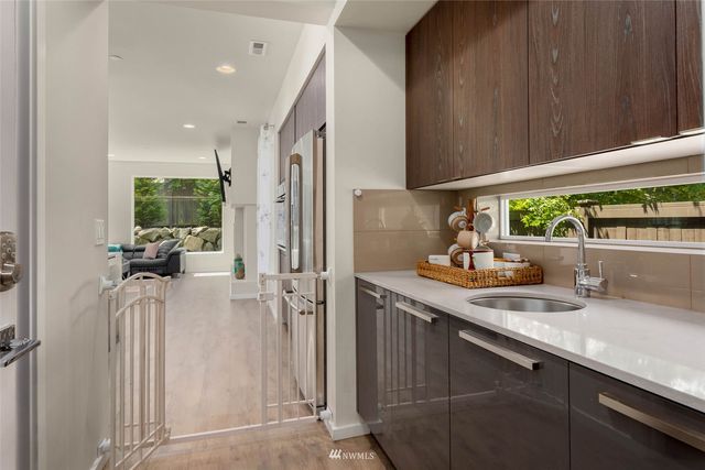 a kitchen with a sink stainless steel appliances a counter top space and cabinets