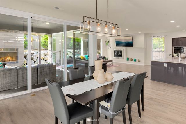 a dining room with furniture a chandelier and wooden floor