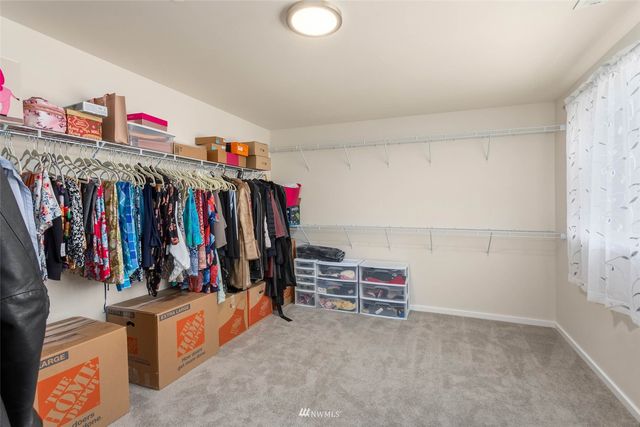 a view of walk in closet with clothes and shoes