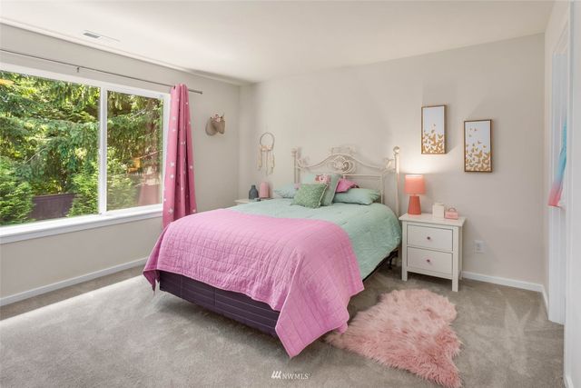 a spacious bedroom with a bed and a large window