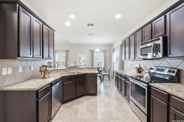 a kitchen with stainless steel appliances granite countertop a sink stove and cabinets