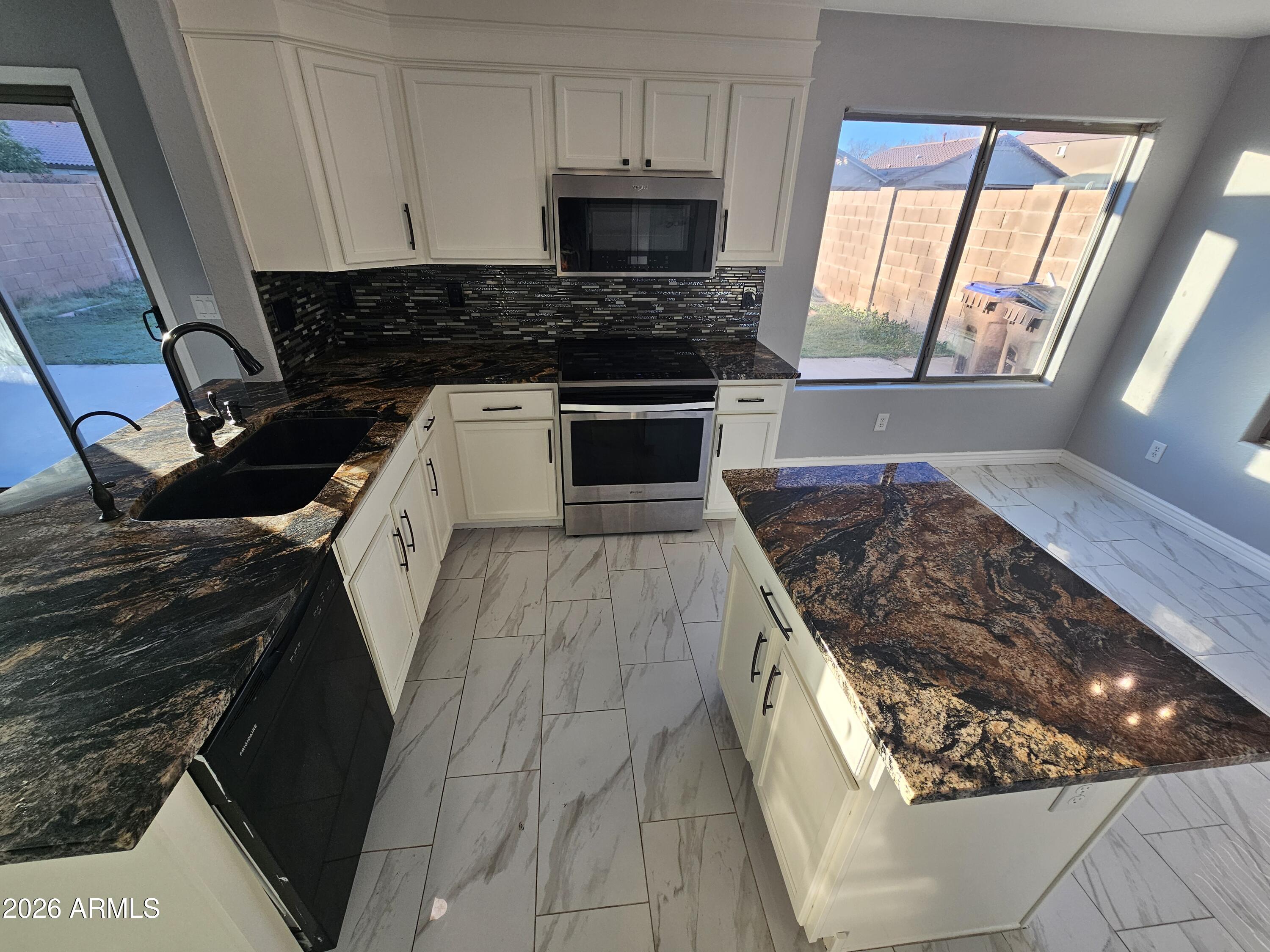 941 Mountain View Road San Tan Valley, AZ 85143 - Photo 2 of 48 a kitchen with wooden cabinets and a stove top oven