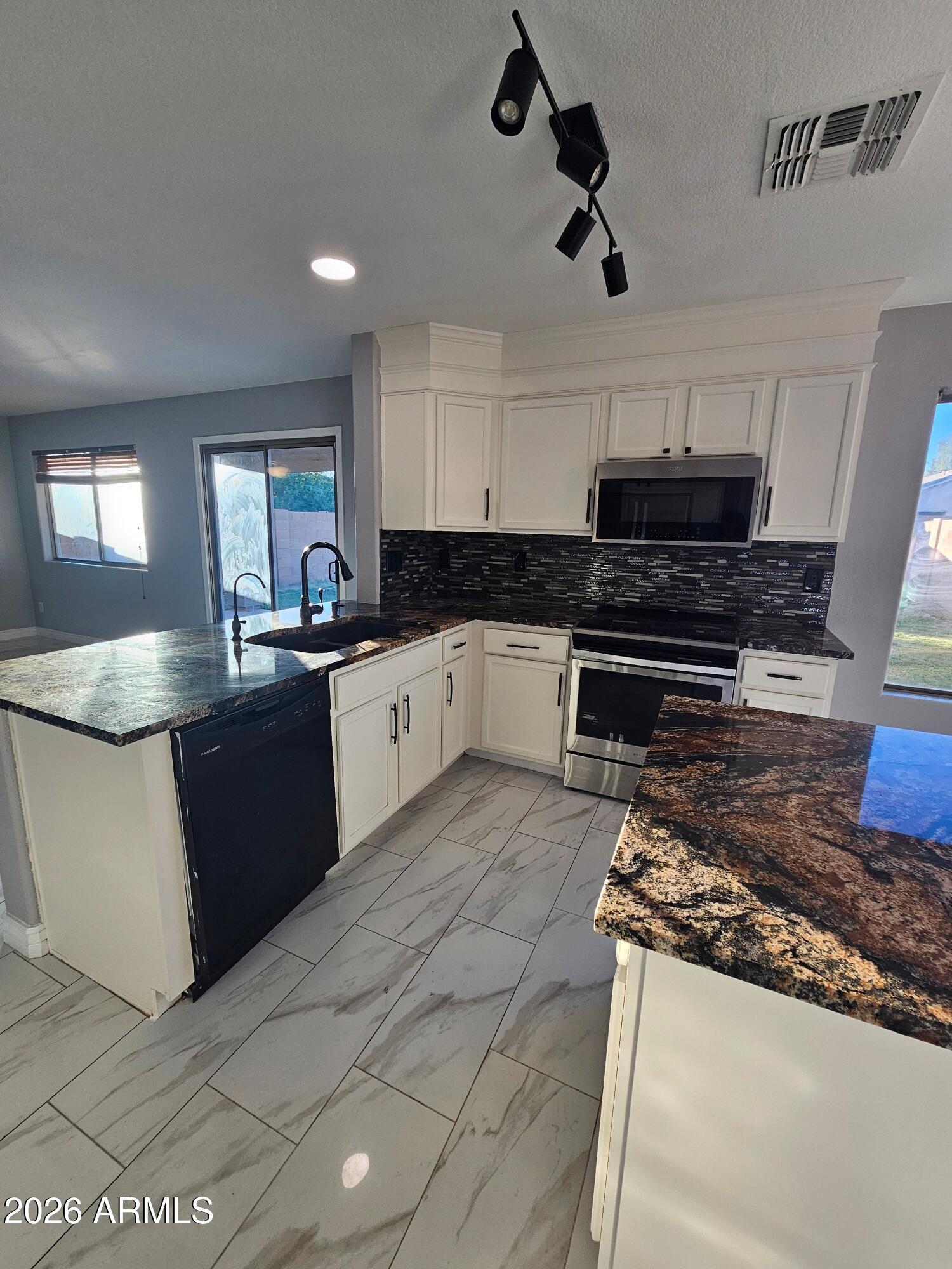 941 Mountain View Road San Tan Valley, AZ 85143 - Photo 3 of 48 a kitchen with stainless steel appliances granite countertop a sink and stove