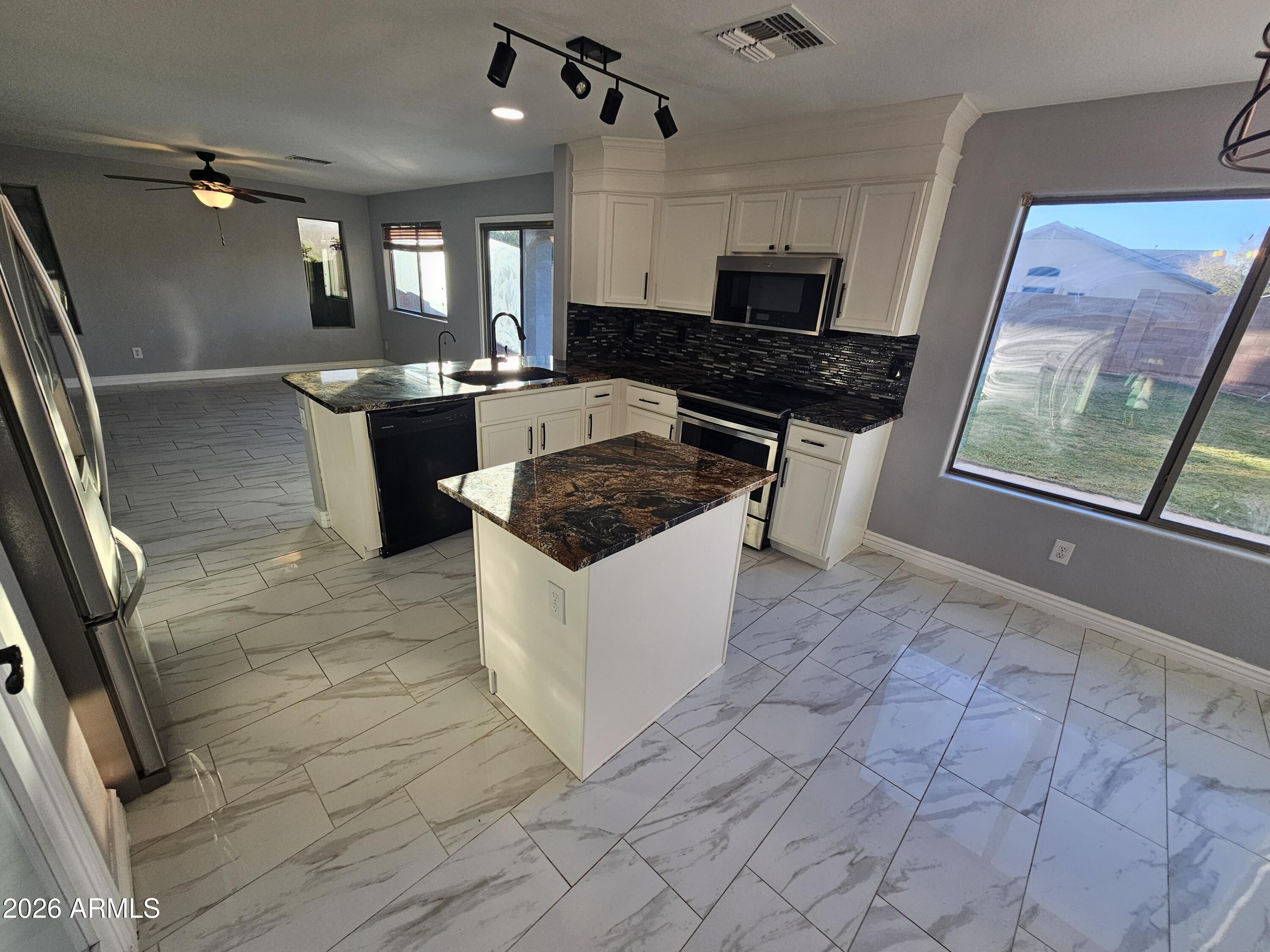 941 Mountain View Road San Tan Valley, AZ 85143 - Photo 4 of 48 a kitchen with granite countertop a stove a sink a refrigerator a counter top space and cabinets