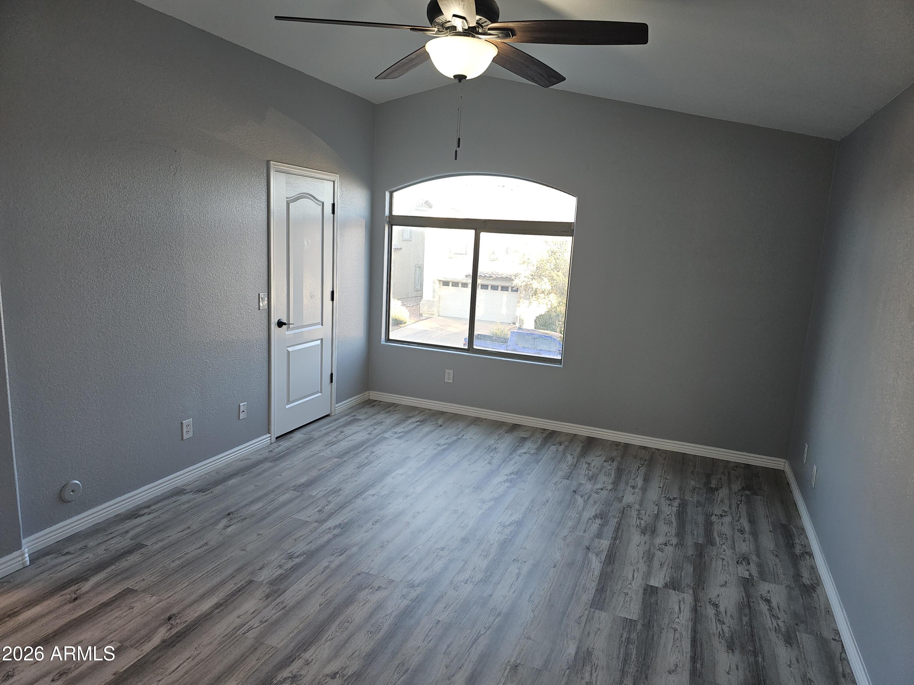 941 Mountain View Road San Tan Valley, AZ 85143 - Photo 42 of 48 an empty room with wooden floor chandelier fan and windows