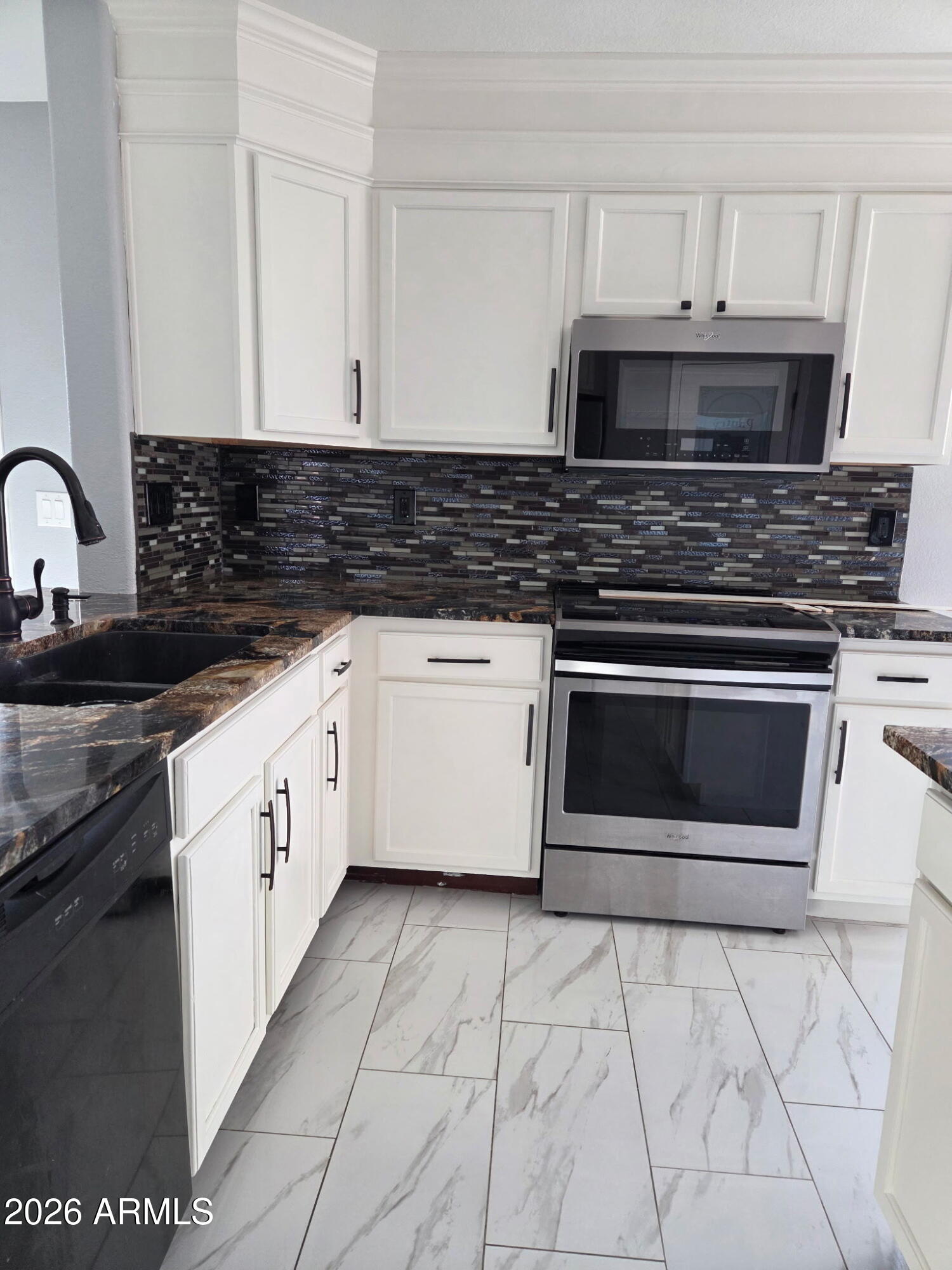941 Mountain View Road San Tan Valley, AZ 85143 - Photo 5 of 48 a kitchen with granite countertop a stove top oven microwave and cabinets