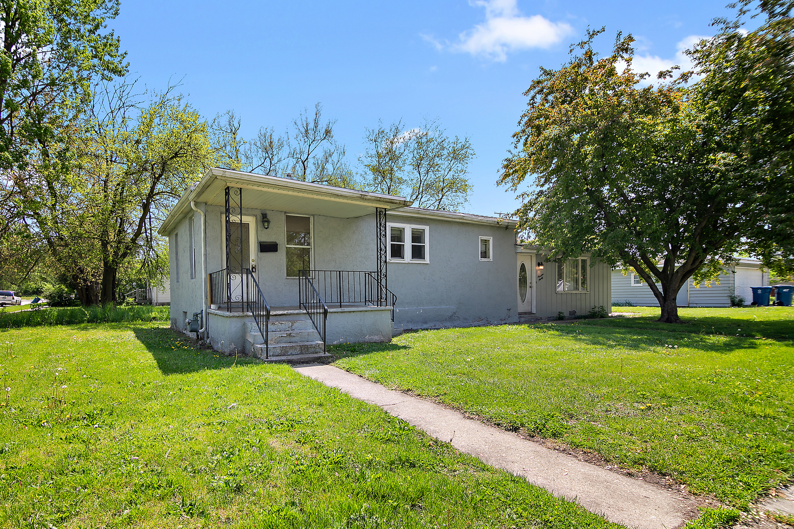 a view of a house with a big yard and a large tree