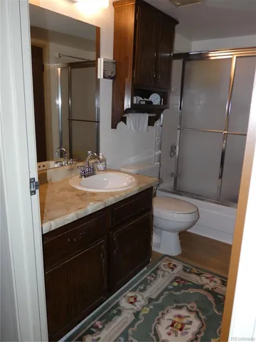 a bathroom with a sink a toilet a mirror and shower