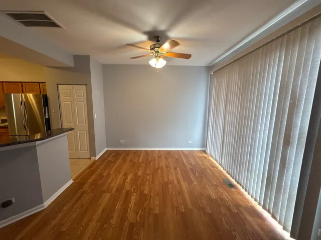 a view of a livingroom with a ceiling fan and wooden floor