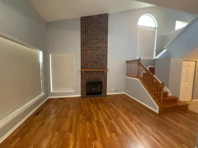 a view of a livingroom with wooden floor and staircase