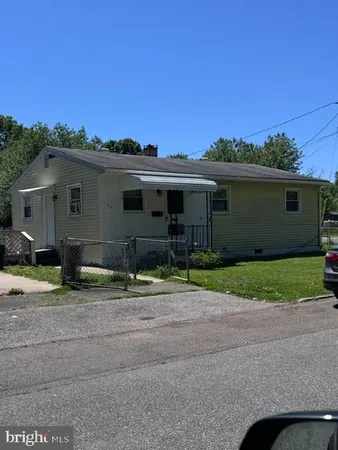 a backyard of a house with plants and a tree
