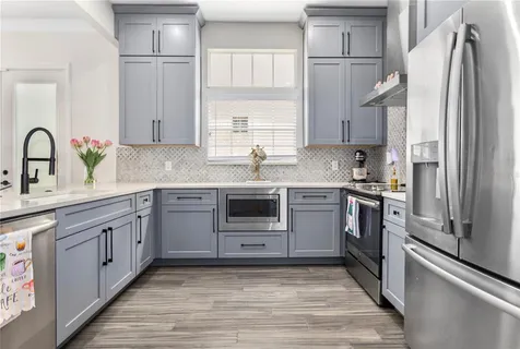 a kitchen with stainless steel appliances granite countertop a refrigerator sink and stove