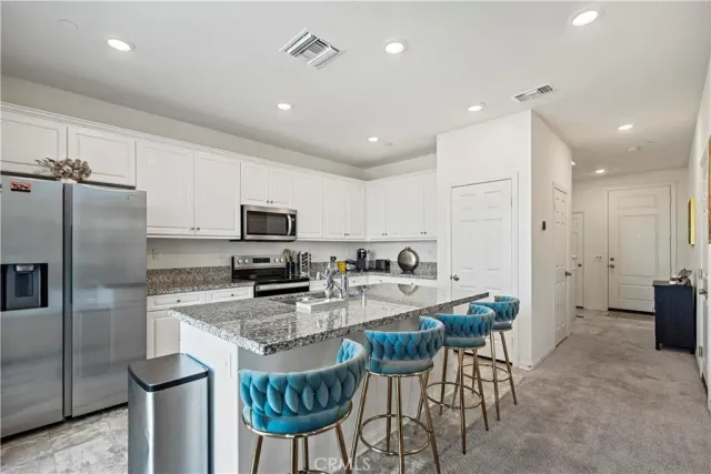 a kitchen with stainless steel appliances granite countertop a stove a sink a refrigerator and a refrigerator