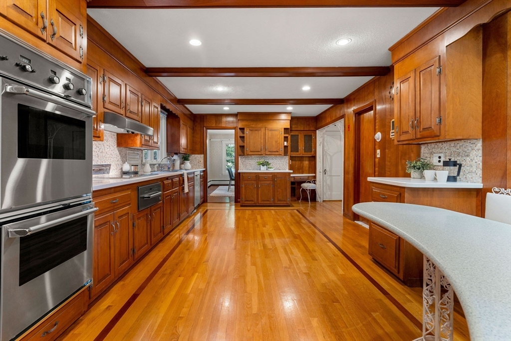 36 Independence Avenue Lexington, MA 02420 - Photo 12 of 33 a large kitchen with stainless steel appliances a large counter top a stove and a wooden floors