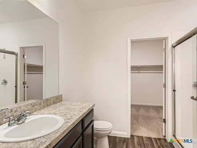 a bathroom with a granite countertop sink toilet and a mirror