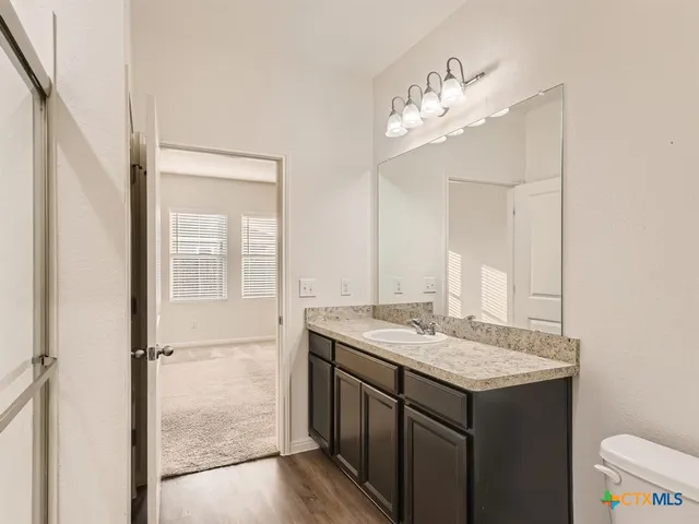 a bathroom with a granite countertop sink a mirror and a vanity
