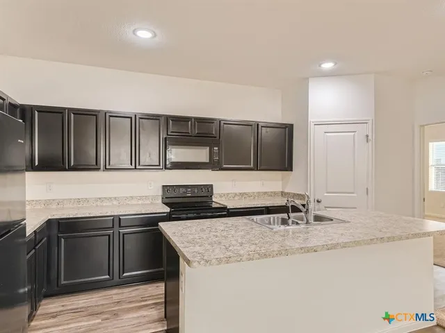a kitchen with stainless steel appliances granite countertop a sink and stove
