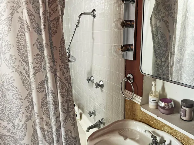a bathroom with a granite countertop sink and a shower curtain