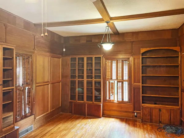 a view of empty room with wooden floor and windows