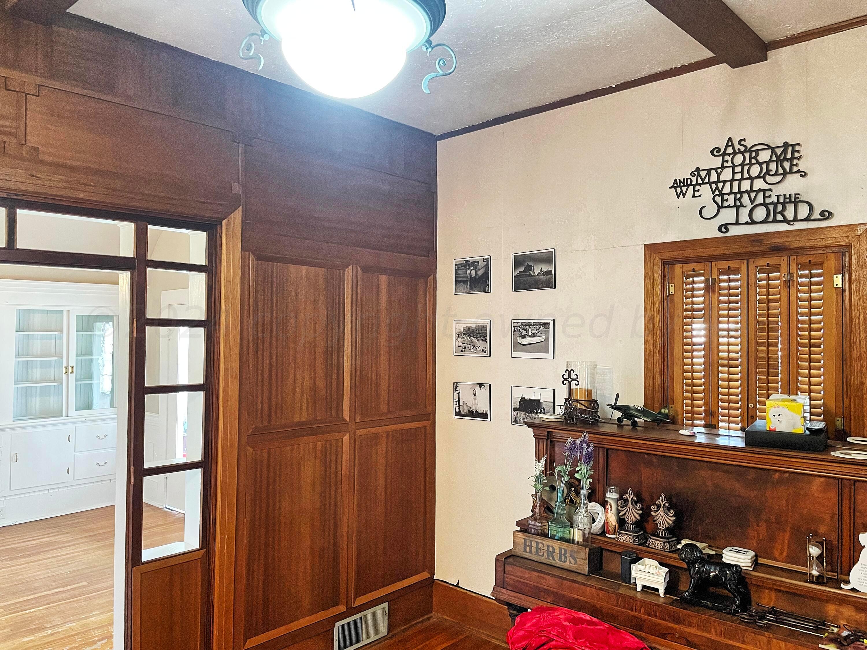 302 South Baylor Street Perryton, TX 79070 - Photo 4 of 21 a room with lots of wooden furniture and windows