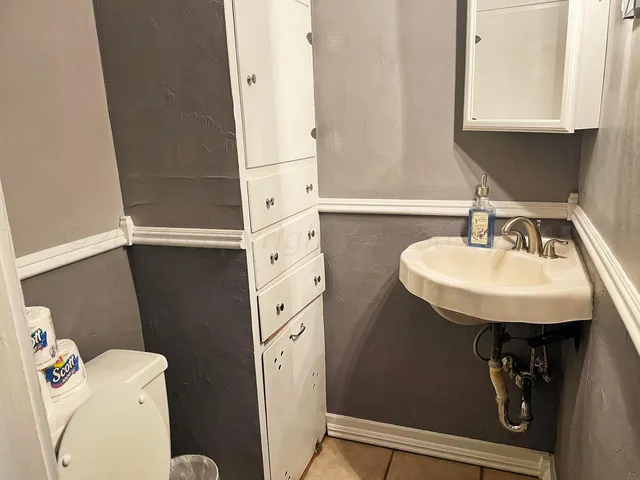 a bathroom with a sink toilet and mirror