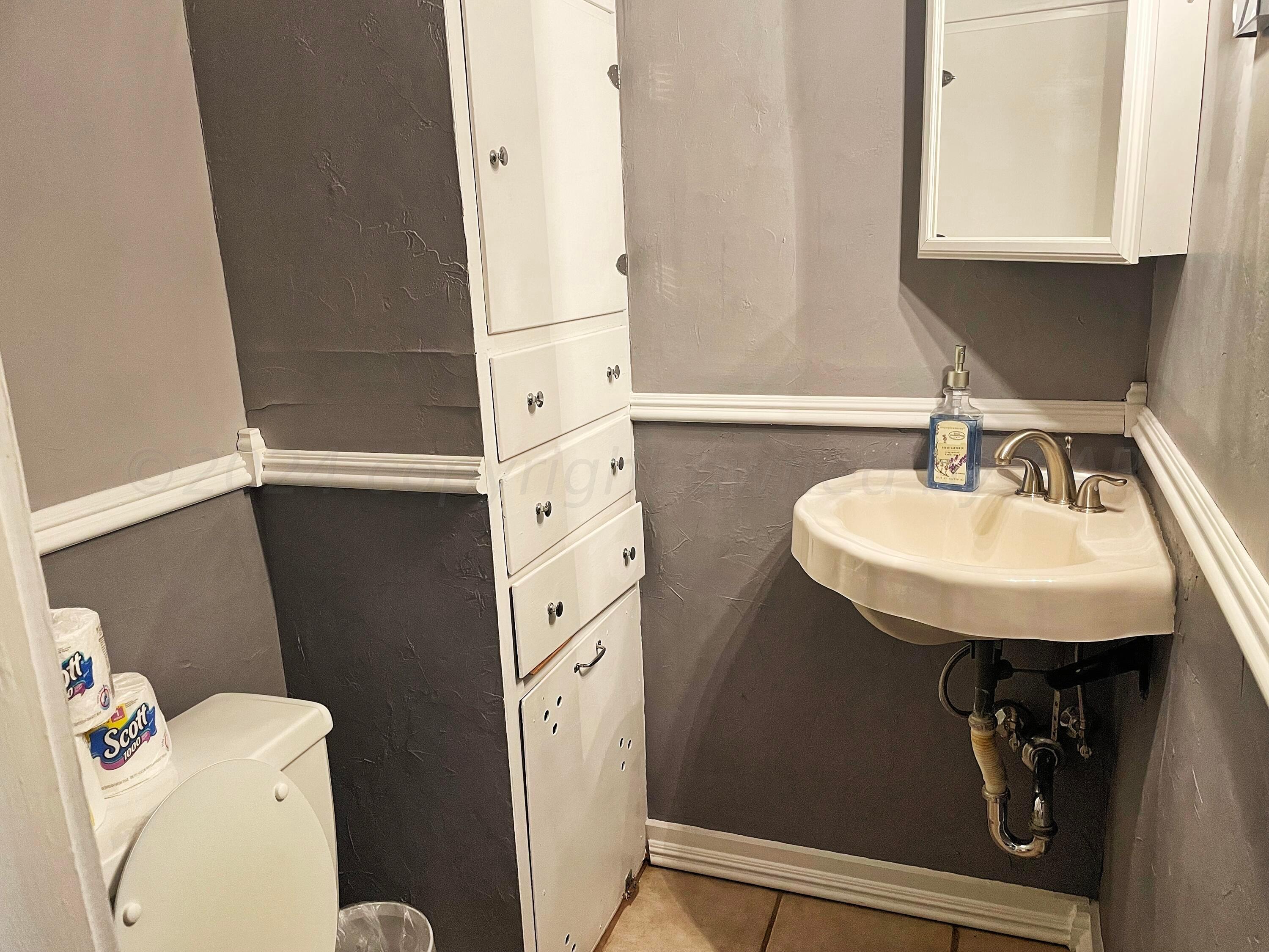 302 South Baylor Street Perryton, TX 79070 - Photo 9 of 21 a bathroom with a sink toilet and mirror