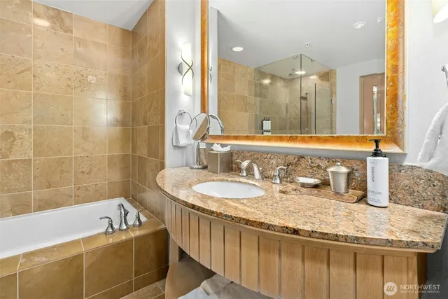 a bath tub sitting next to a bathroom sink and a mirror