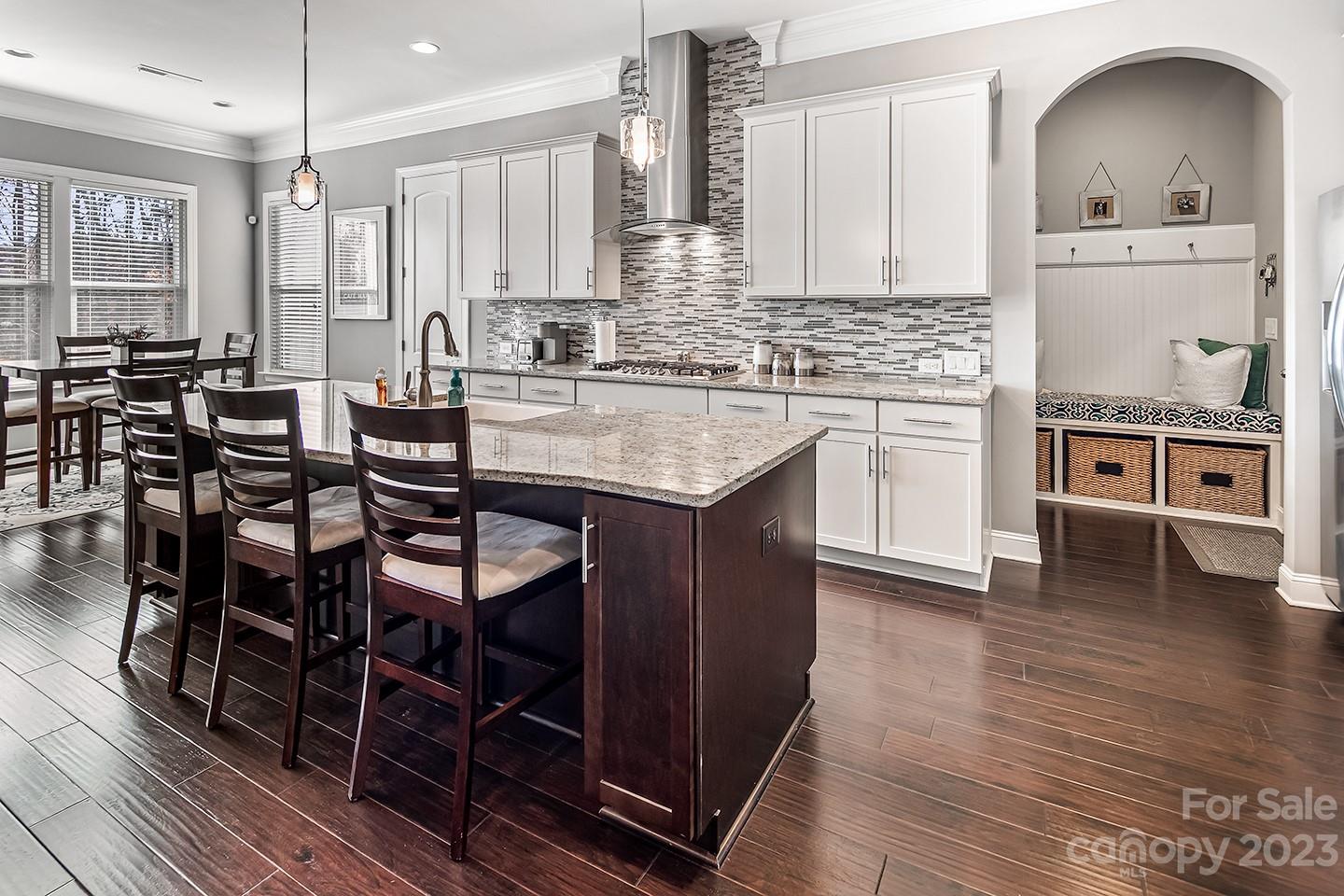 6004 Tremont Drive Indian Trail, NC 28079 - Photo 12 of 40 a kitchen with stainless steel appliances kitchen island granite countertop a stove a sink and white cabinets with wooden floor