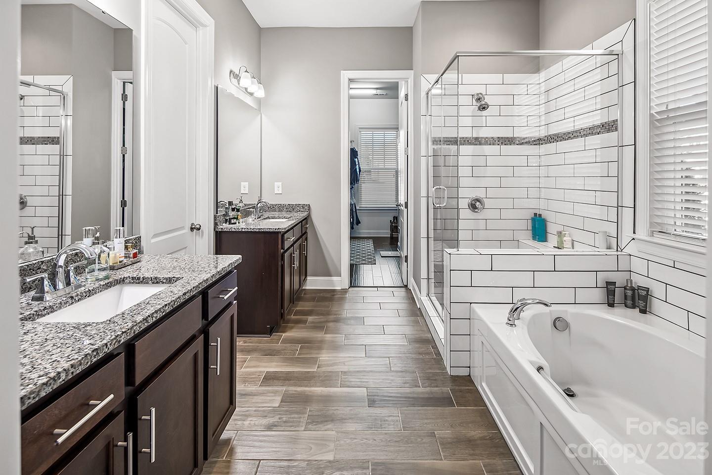 6004 Tremont Drive Indian Trail, NC 28079 - Photo 22 of 40 a large bathroom with a granite countertop double vanity sink a bathtub and shower