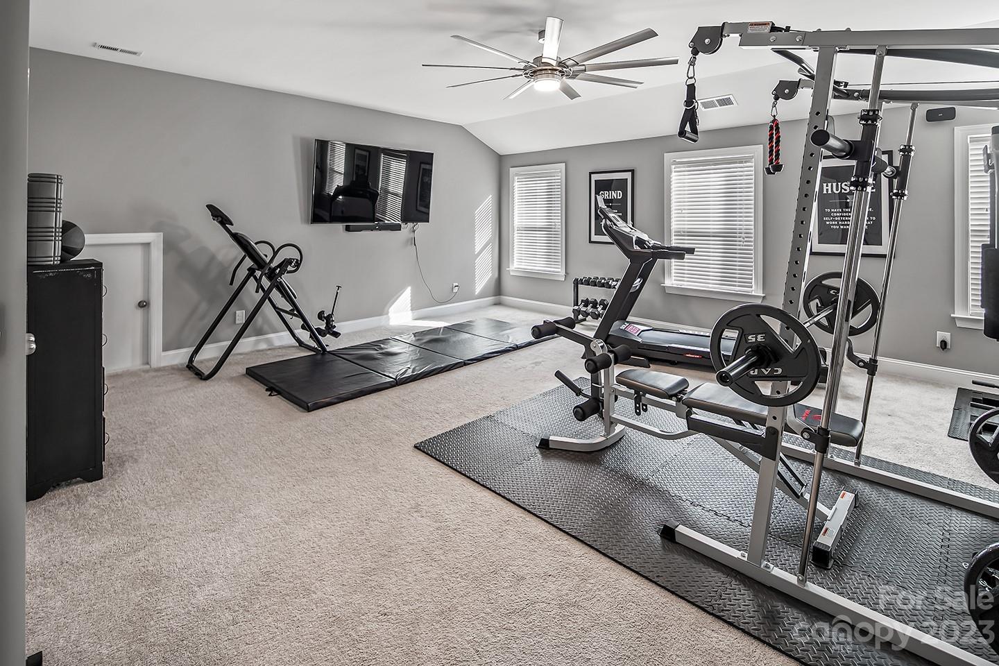 6004 Tremont Drive Indian Trail, NC 28079 - Photo 27 of 40 a room with gym equipment and a flat screen tv