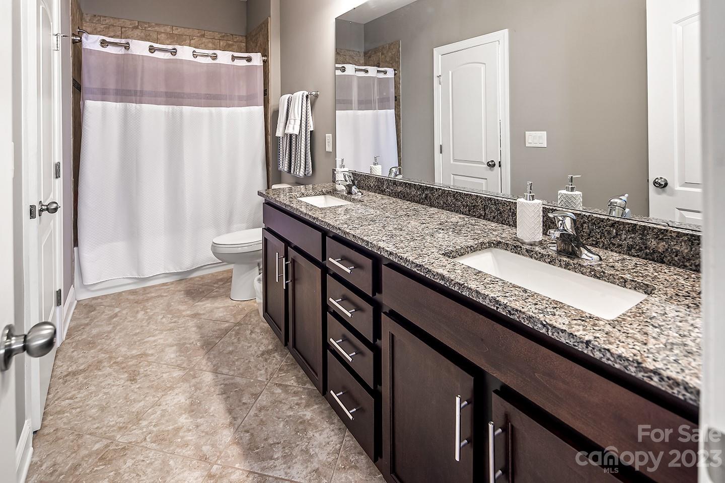 6004 Tremont Drive Indian Trail, NC 28079 - Photo 32 of 40 a bathroom with a granite countertop sink and a mirror