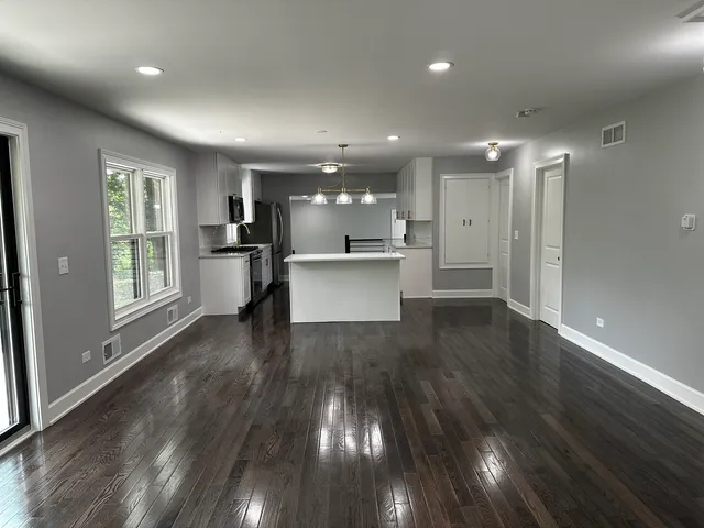 a view of a kitchen with wooden floor and a window