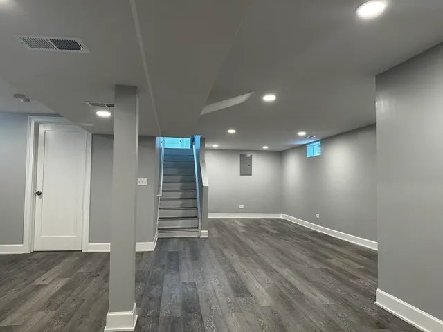 an empty room with wooden floor and stairs