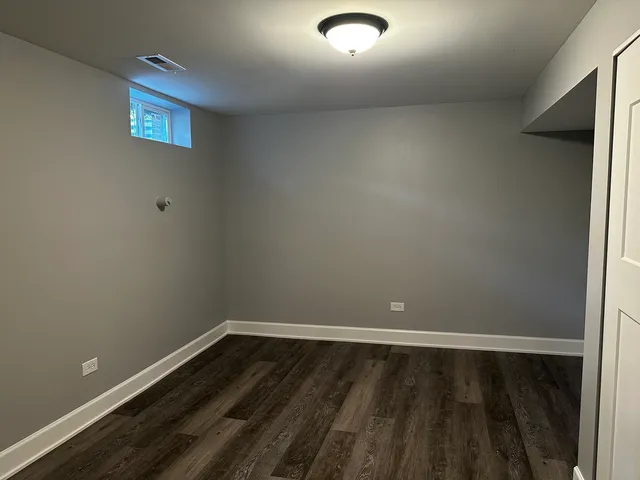 a view of a room with wooden floor and window