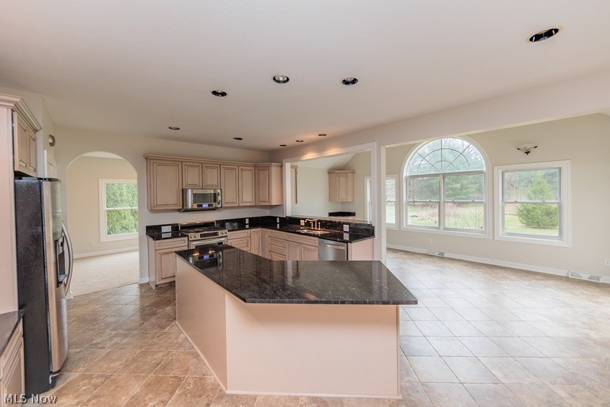 6947 Som Center Road Solon, OH 44139 - Photo 28 of 50 Kitchen featuring light tile floors, stainless steel appliances, dark stone countertops, and a center island