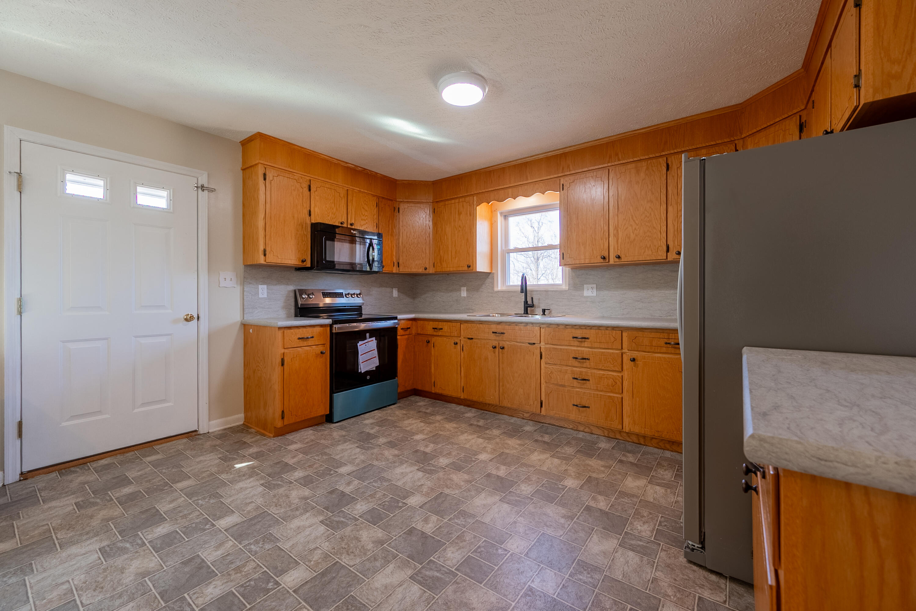 2448 Kyle Weeks Road Southwest Willis, VA 24380 - Photo 16 of 65 a kitchen with stainless steel appliances granite countertop a stove sink and cabinets