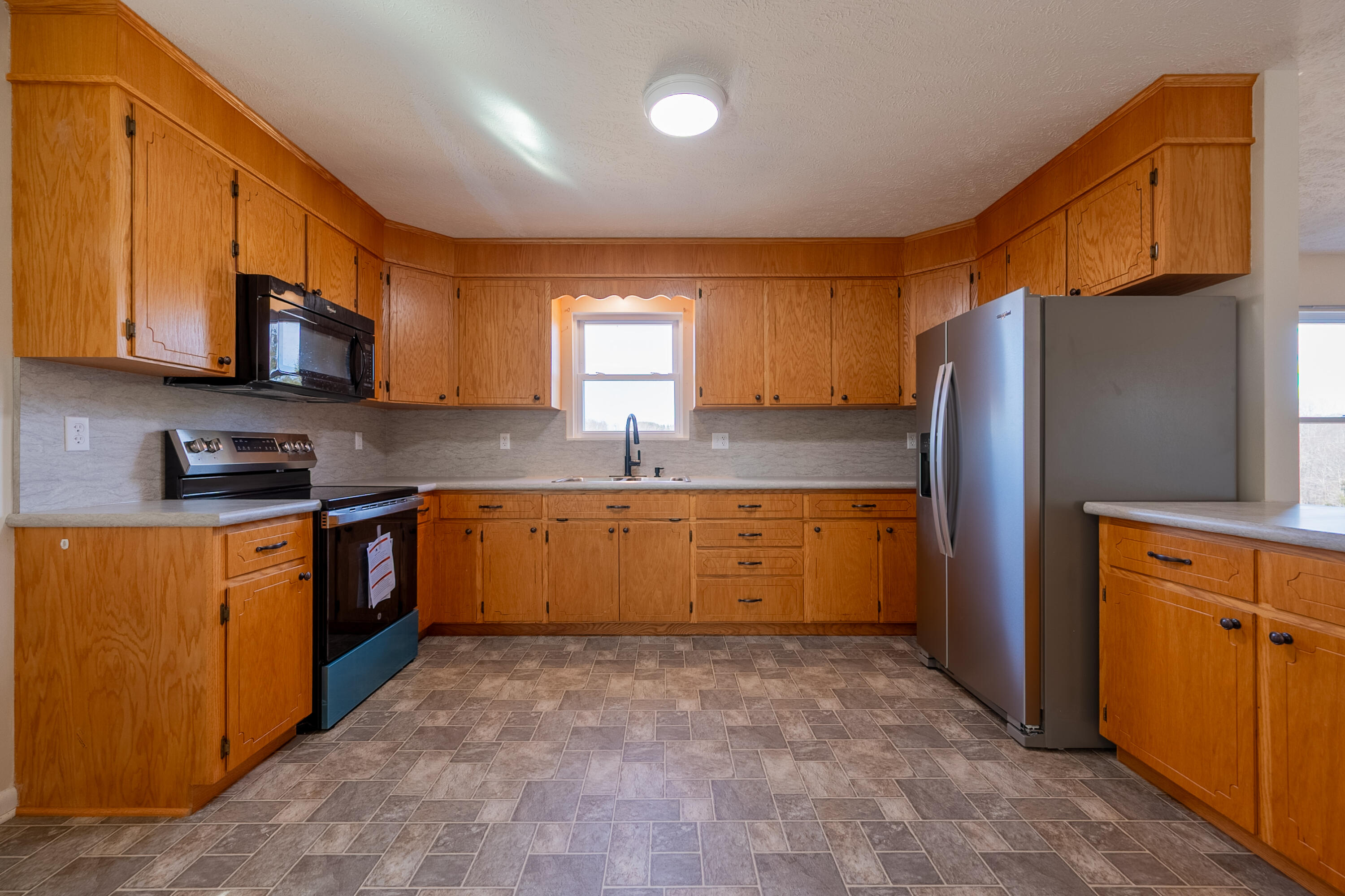 2448 Kyle Weeks Road Southwest Willis, VA 24380 - Photo 17 of 65 a kitchen with stainless steel appliances granite countertop a refrigerator and a stove top oven