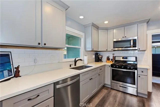 a kitchen with sink a microwave a stove and cabinets