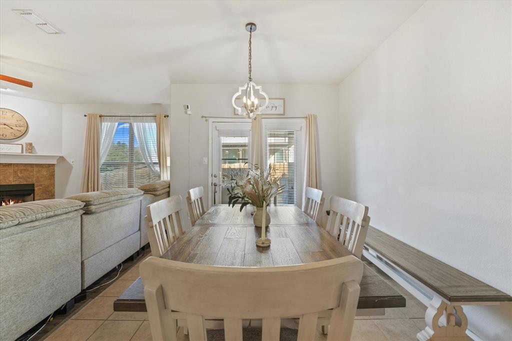 3801 Surf Street Denton, TX 76208 - Photo 12 of 29 Tiled dining room featuring a fireplace and suspended lighting