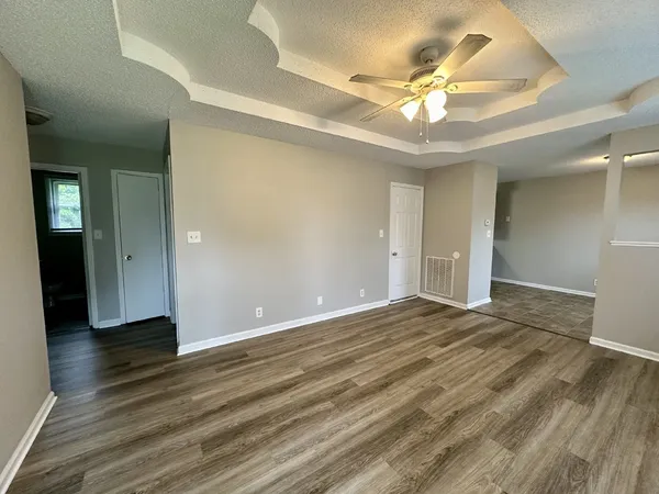 a view of an empty room with wooden floor