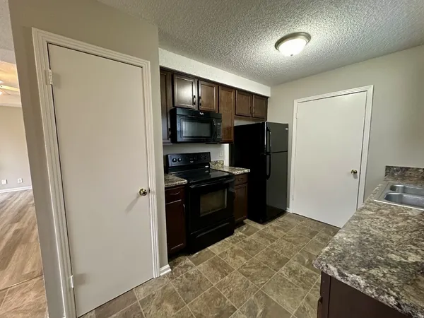a kitchen with a refrigerator and a stove top oven