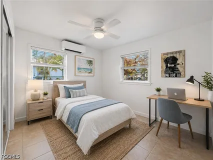 a bedroom with a bed a desk and chair with a large mirror