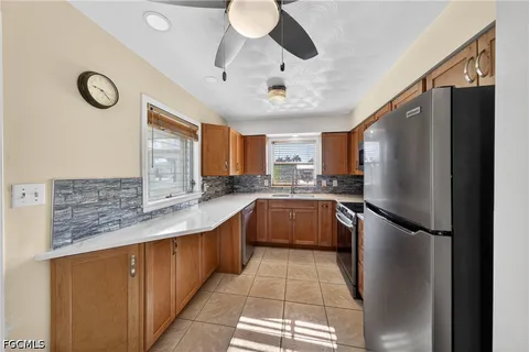 a kitchen with stainless steel appliances granite countertop a refrigerator a stove a sink a washer and dryer