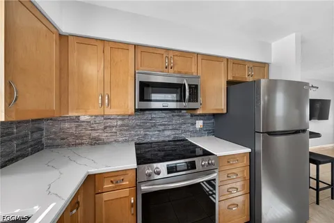 a kitchen with stainless steel appliances a refrigerator a stove a sink and a refrigerator