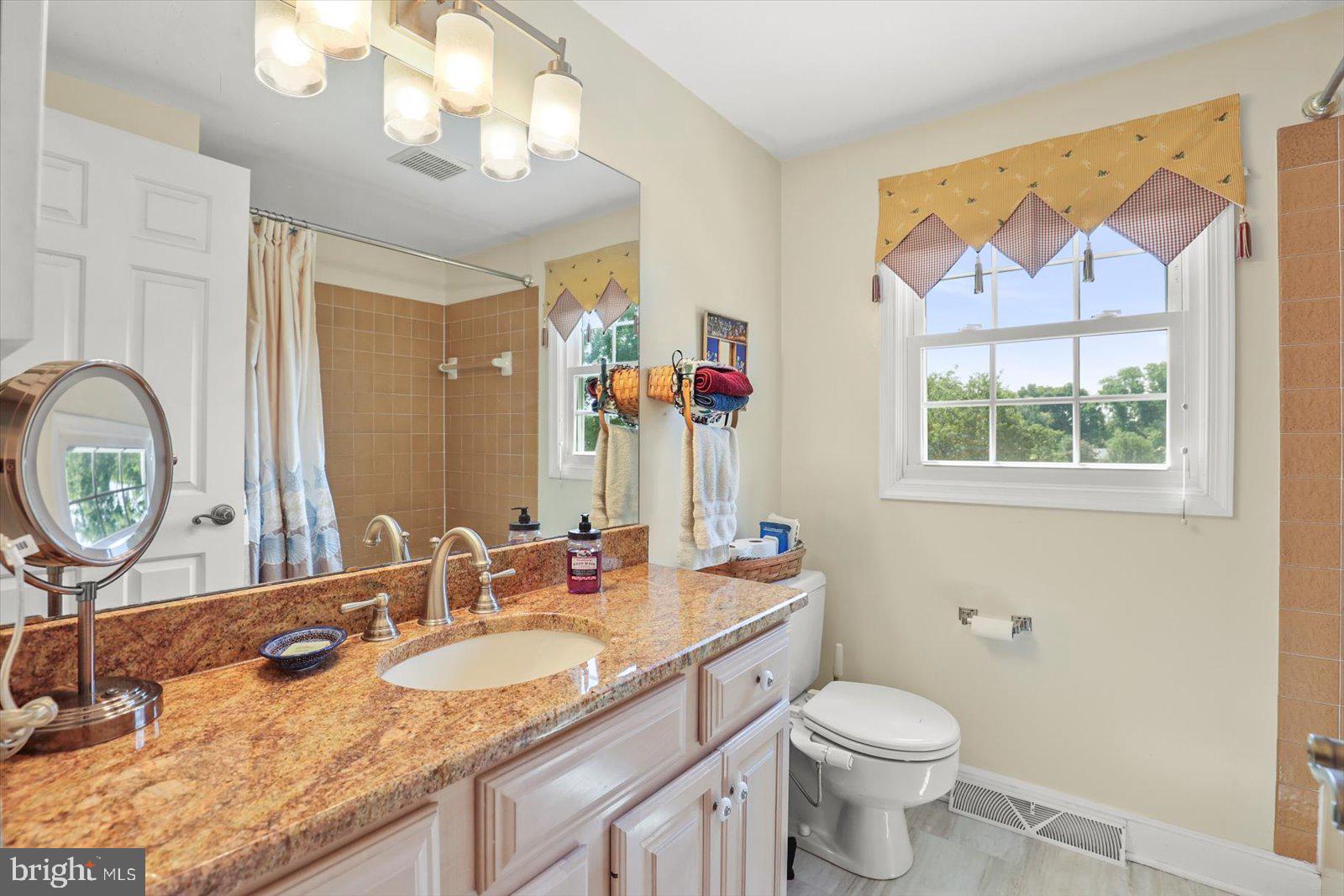 124 Lexington Road York, PA 17402 - Photo 23 of 56 a bathroom with a granite countertop toilet a sink and a mirror