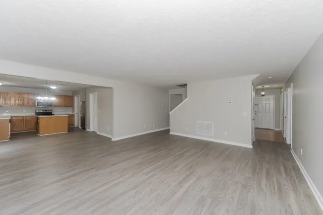 a view of a big room with wooden floor and windows