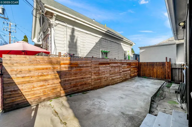 a view of a white house with a large space balcony and parking space