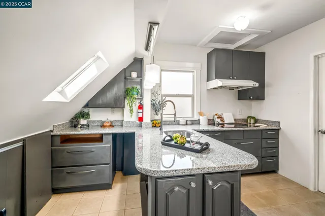 a kitchen with granite countertop a sink stove and cabinets