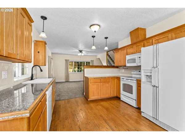 a kitchen with stainless steel appliances granite countertop a sink a stove and a refrigerator